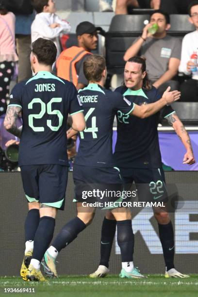 Australia's midfielder Jackson Irvine celebrates with his teammates after scoring their first goal during the Qatar 2023 AFC Asian Cup Group B...