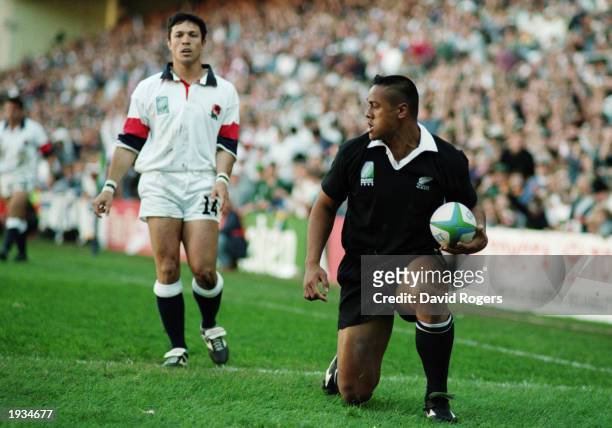 Dejected Tony Underwood of England can only look on as Jonah Lomu of New Zealand scores another try in an awesome performance during the 1995 Rugby...