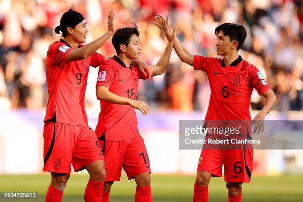 Lee Kang-In of South Korea celebrates scoring their third goal with Cho Gue-Sung and Hwang In-Beom during the AFC Asian Cup Group E match between...