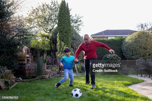 grandfather and grandson having fun in the garden - young at heart stock pictures, royalty-free photos & images