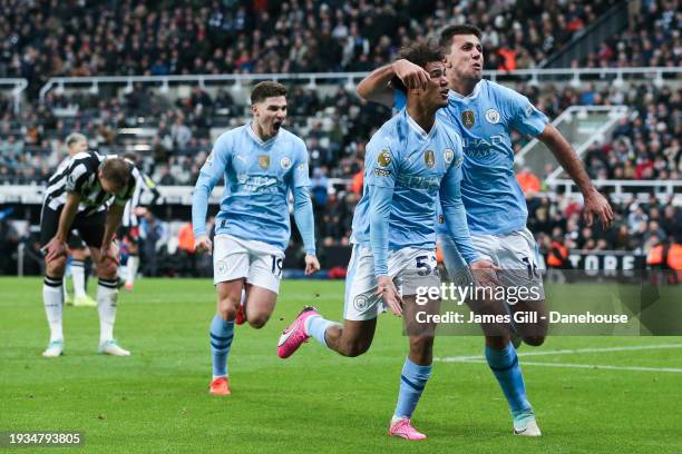 Oscar Bobb of Manchester City celebrates his side's third goal with Julian Alvarez and Rodri during the Premier League match between Newcastle United...