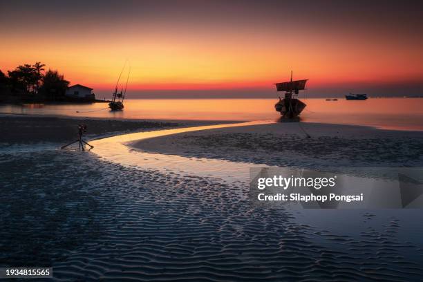 reflection of single boat with burning sky during sunrise/sunset in thailand, rayong province. - ship on fire stock pictures, royalty-free photos & images