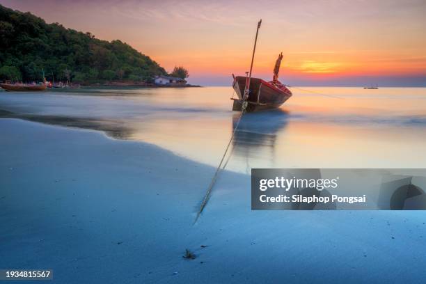 thai fishing boat used as a vehicle for finding fish in the sea at burning sky during sunrise/sunset - ship on fire stock pictures, royalty-free photos & images