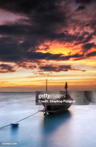 reflection of single boat with burning sky during sunrise/sunset - ship on fire stock pictures, royalty-free photos & images