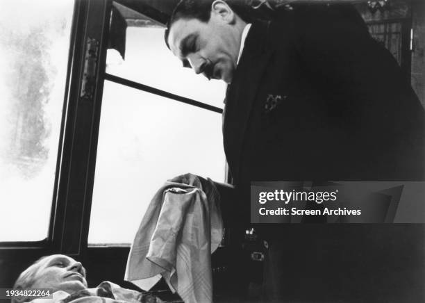 Albert Finney as Hercule Poirot inspects the deceased body of Richard Widmark in a scene from the 1974 film version 'Murder on the Orient Express'.
