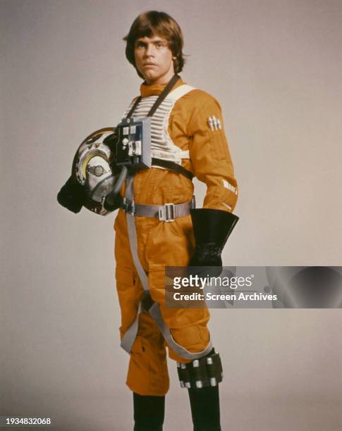 Mark Hamill in orange flight suit as Luke Skywalker in a publicity portrait for the George Lucas 1977 film 'Star Wars A New Hope'.