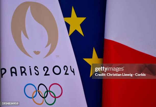 The flag of the Paris 2024 Olympic Games is seen near the French national flag and the European flag at the entrance of the Elysee Palace during a...