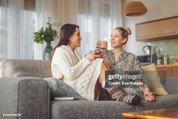 giovani donne a casa - bevanda calda foto e immagini stock