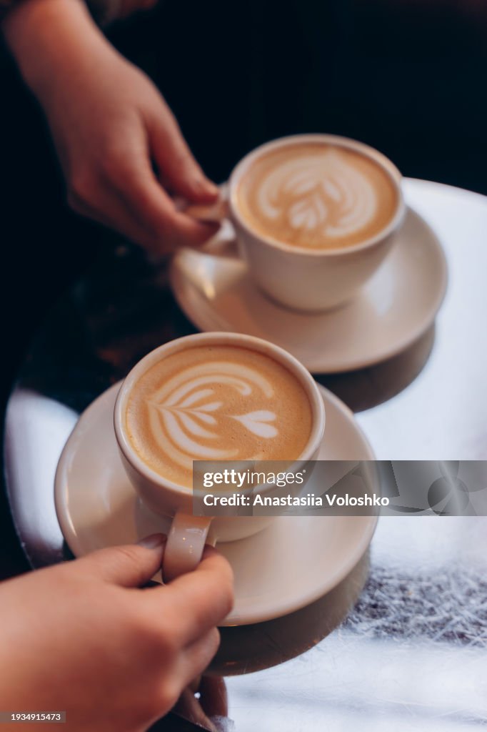 Two cups of specialty cappuccino with art on top