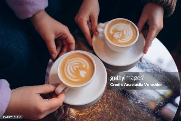 two cups of tasty specialty cappuccino with art on top - tasty stock pictures, royalty-free photos & images