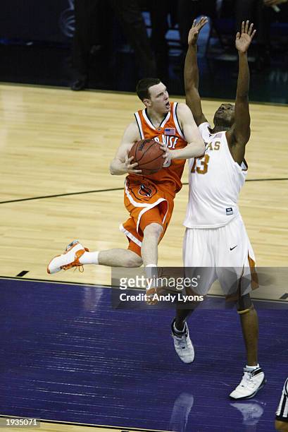 Gerry McNamara of the Syracuse University Orangeman shoots against Sydmill Harris of the University of Texas at Austin Longhorns during the semifinal...