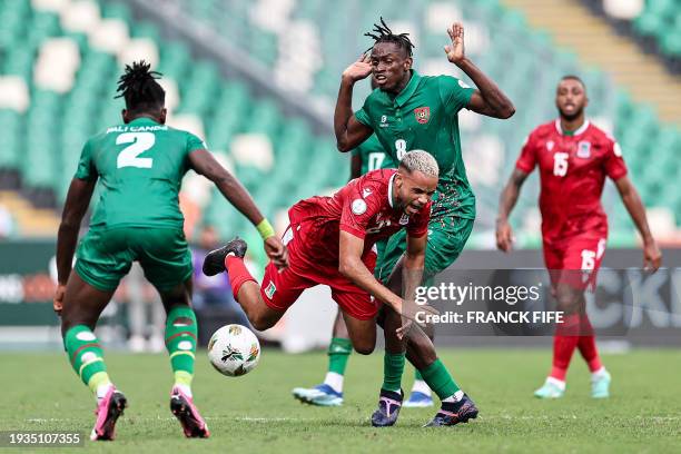 Equatorial Guinea's midfielder Pablo Ganet falls as he fights for the ball with Guinea-Bissau's defender Fali Cande and Guinea-Bissau's midfielder...