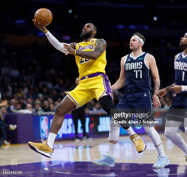 Los Angeles, CA Lakers forward LeBron James, #23, left, goes up for a basket as Mavericks point guard Luka Doni, #77, defends in the first half at...