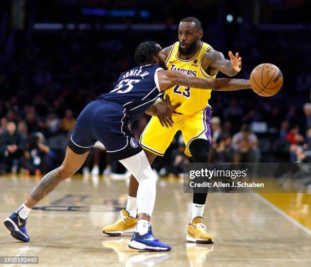Los Angeles, CA Lakers forward LeBron James, #23, right, passes the ball past Mavericks forward Derrick Jones Jr., #55, left, in the first half at...