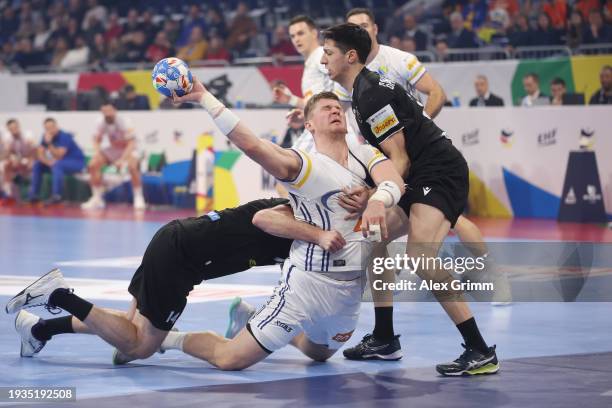 Adin Faljic of Bosnia is challenged by Teimuraz Orjokinidze and Miriani Gavashlishvili of Georgia during the Men's EHF Euro 2024 preliminary round...