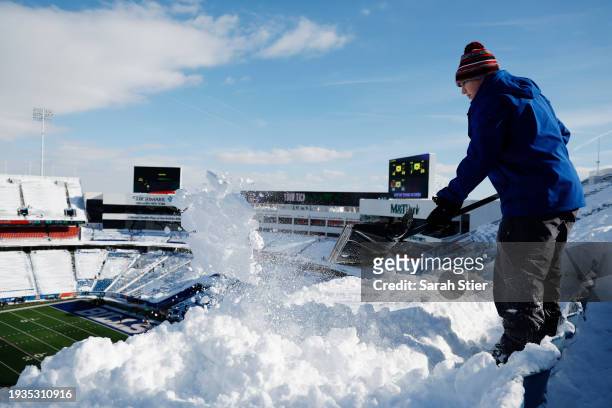 Brady Reinagel shovels snow before the AFC Wild Card playoff game between the Buffalo Bills and Pittsburgh Steelers at Highmark Stadium on January...