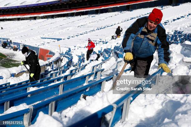 Worker shovels snow before the AFC Wild Card playoff game between the Buffalo Bills and Pittsburgh Steelers at Highmark Stadium on January 15, 2024...
