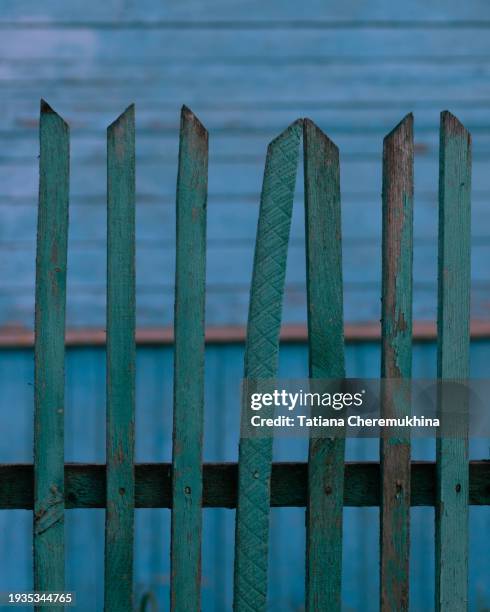 a turquoise picket fence against a background of a blue wooden structure. - draft period closes stock pictures, royalty-free photos & images