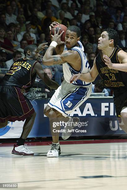 Dahntay Jones of Duke drives to the basket through J.R. Wallace and Tony Bowne of Central Michigan during the second round of the NCAA Tournament on...