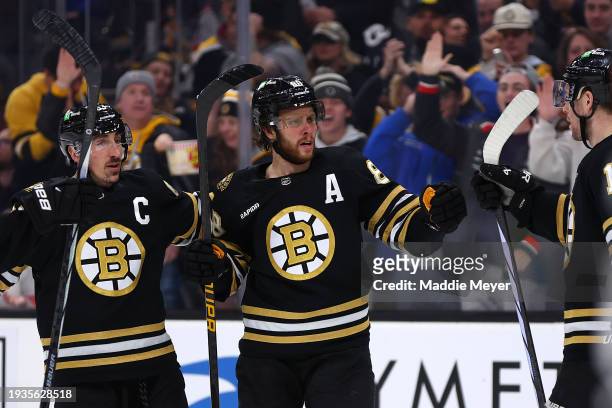 David Pastrnak of the Boston Bruins celebrates with Brad Marchand and Charlie Coyle after scoring a goal against the New Jersey Devils during the...