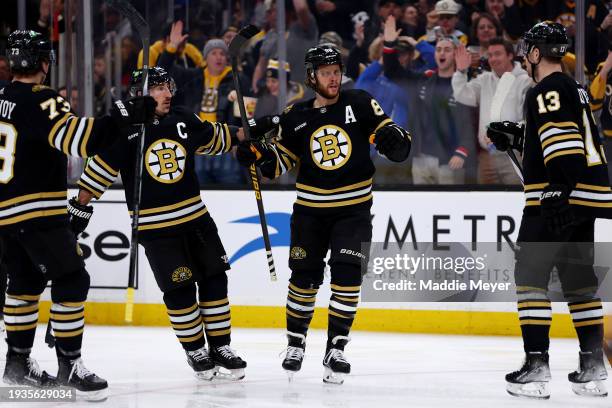 David Pastrnak of the Boston Bruins celebrates with Brad Marchand, Charlie McAvoy, and Charlie Coyle after scoring a goal against the New Jersey...
