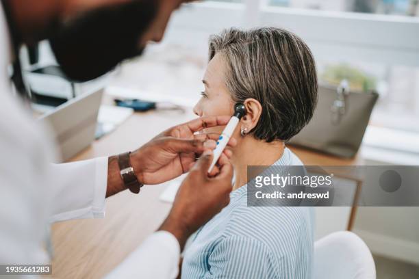 doctor analyzing human ear - audiologist stock-fotos und bilder