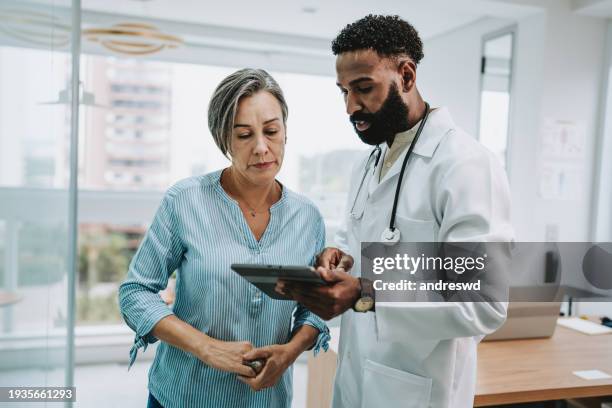 arzt spricht mit patient mit digitalem tablet - patient arzt stock-fotos und bilder