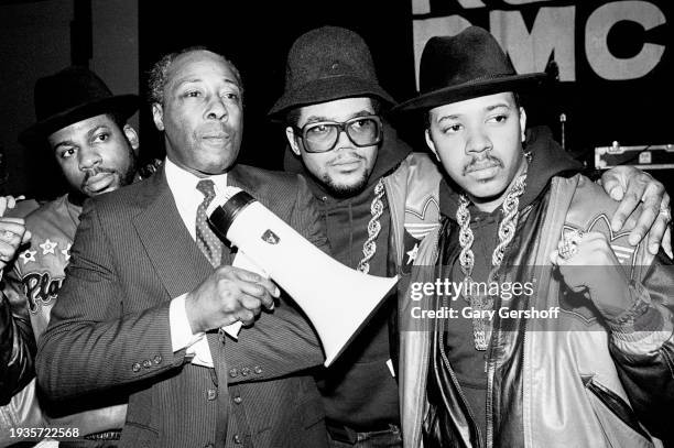 View of American educator and Eastside High School principal Joe Louis Clark with the members of American Hip Hop group Run-DMC on a stage at the...