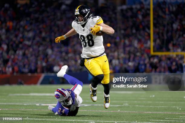 Pat Freiermuth of the Pittsburgh Steelers carries the ball against Kaiir Elam of the Buffalo Bills during the second quarter at Highmark Stadium on...