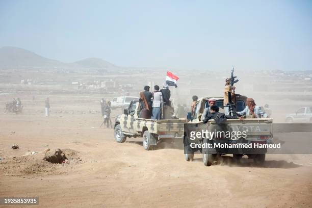 Houthi followers ride vehicles with artillery during a tribal gathering on January 14, 2024 on the outskirts of Sana'a, Yemen. Houthi followers...