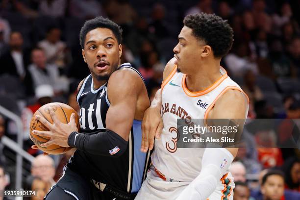 Trent Forrest of the Atlanta Hawks works against Keldon Johnson of the San Antonio Spurs during the first half at State Farm Arena on January 15,...