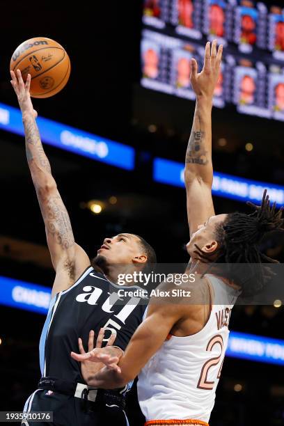 Dejounte Murray of the Atlanta Hawks shoots over Devin Vassell of the San Antonio Spurs during the first half at State Farm Arena on January 15, 2024...