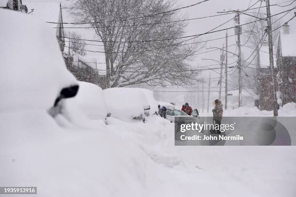 Neighbors work together to help clear vehicles on January 18, 2024 in Lackawanna, New York. The suburb of Buffalo was one of the areas hit the...