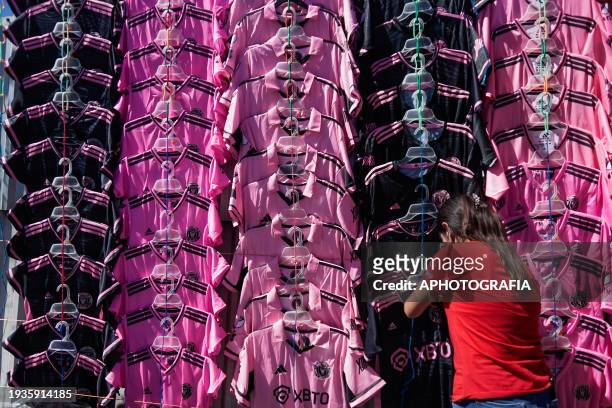 Woman checks Miami FC jerseys from Argentine player Lionel Messi at an avenue ahead of tomorrow's friendly match between El Salvador and Inter Miami...