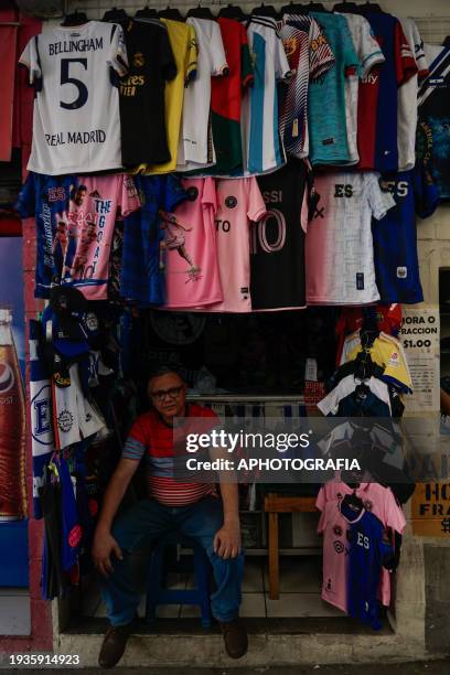 Vendor rests at his stand selling sports jerseys in the historic center ahead of tomorrow's friendly match between El Salvador and Inter Miami on...