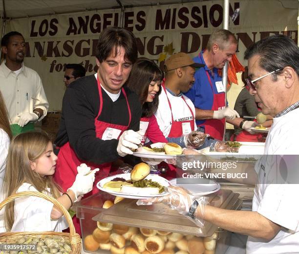 Actor Tony Danza and daughter Emily prepare traditional Thanksgiving Day dinners to be served by volunteers to over 5,000 homeless people at the Los...