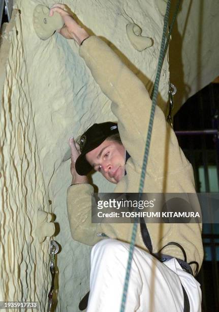 Actor Chris O'Donnell climbs a training wall for rock climbers at the Ginza district in Tokyo 30 November 2000 in a promotion of his latest movie,...