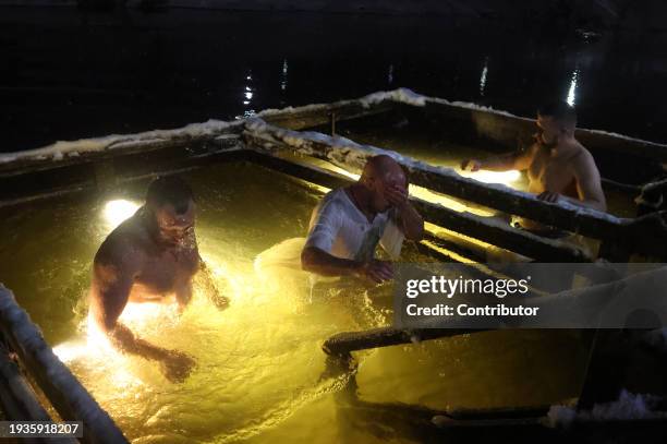 Russian Orthodox belivers bath in an ice water of the Istra river, marking the Epiphany, as the air temperature is minus 7 degrees celsius January...