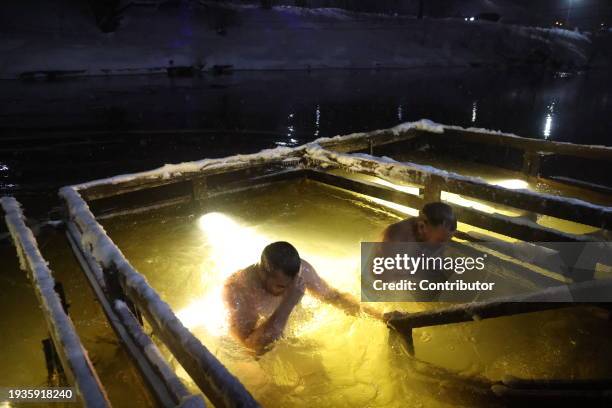 Russian Orthodox believer bathes in an ice water of the Istra river, marking the Epiphany, as the air temperature is minus 7 degrees celsius January...