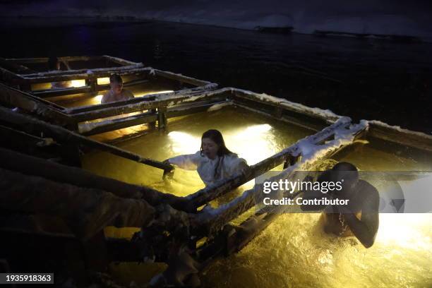 Russian Orthodox belivers cross themselves in an ice water of the Istra river, marking the Epiphany, as the air temperature is minus 7 degrees...