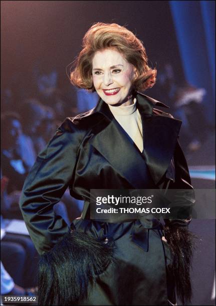 Actress Cyd Charisse presents a short black satin duchess trench coat with fringed "monkey hair" cuffs 22 July in Paris during the Thierry Mugler...