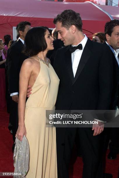 British actor Jude Law speaks with girlfriend Sadie Frost as they arrive at the Shrine Auditorium for the 72nd Annual Academy Awards at the Shrine...