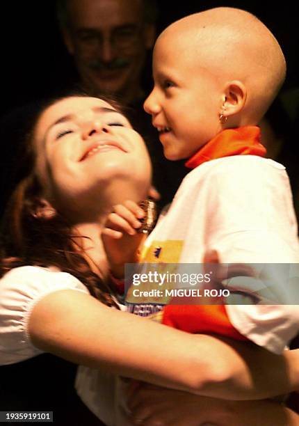 Uruguayan actress Natalia Oreiro, with a child from the Fundacion Peluffo Giguens, participate in a show 20 June 1999 in Montevideo, to collect...