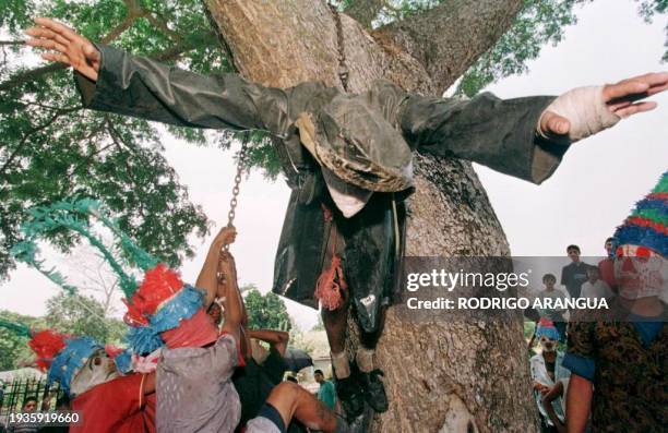 Un hombre disfrazado de "Judas" es colgado de un arbol por los "judios" durante la celebracion de la Semana Santa en la ciudad de Masatepe distante...