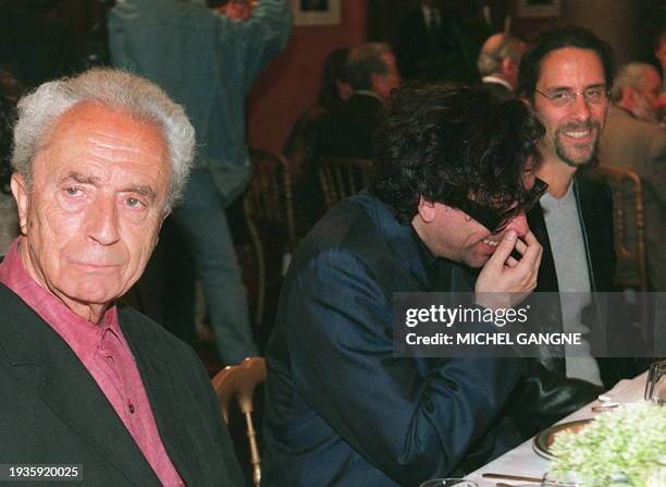 Italian director Michelangelo Antonioni looks away as US directors Tim Burton and Coen share a laugh at a special lunch organized with members of the...