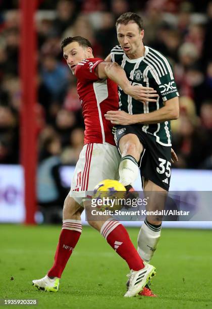 Chris Wood of Nottingham Forest and Jonny Evans of Manchester United challenge during the Premier League match between Nottingham Forest and...