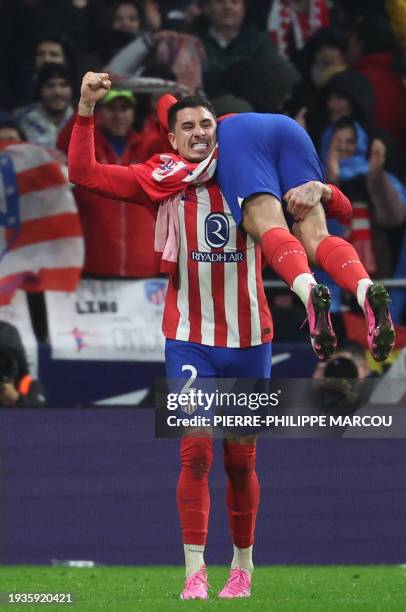 Atletico Madrid's French forward Antoine Griezmann is lifted by Atletico Madrid's Uruguayan defender Jose Gimenez after scoring his team's third goal...