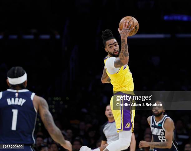 Los Angeles, CA Lakers point guard D'Angelo Russell, #1, center, grabs a rebound over Mavericks guard Jaden Hardy, #1, left, and Mavericks forward...
