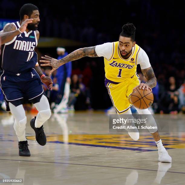 Los Angeles, CA Lakers point guard D'Angelo Russell, #1, right, drives to the hoop as Mavericks point guard Kyrie Irving, #11, defends in the second...