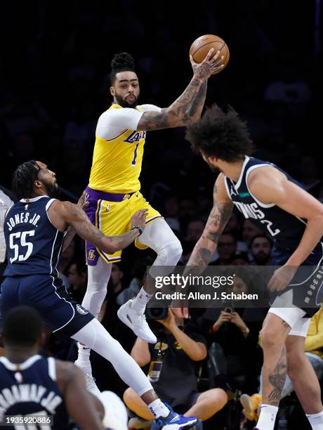 Los Angeles, CA Lakers point guard D'Angelo Russell, #1, center, grabs a rebound over Mavericks forward Derrick Jones Jr., #55, left, and Mavericks...